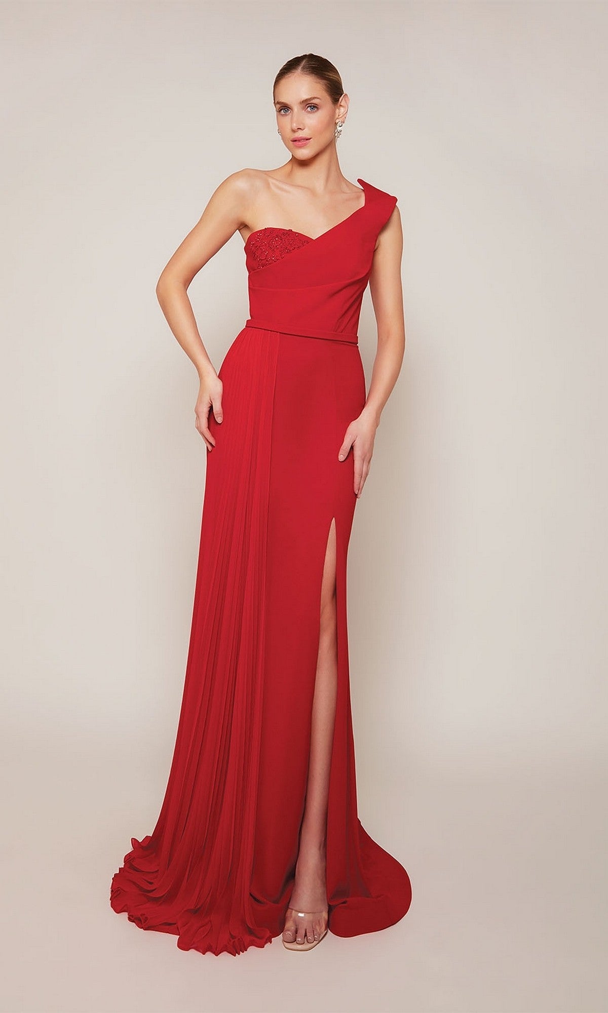 A woman models the Alyce 27650 long formal dress— a floor-length, one-shoulder gown with a side slit—against a plain light background.